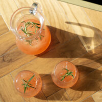 non alcoholic spritz passion fruit flavour in jug with two glasses garnished with rosemary