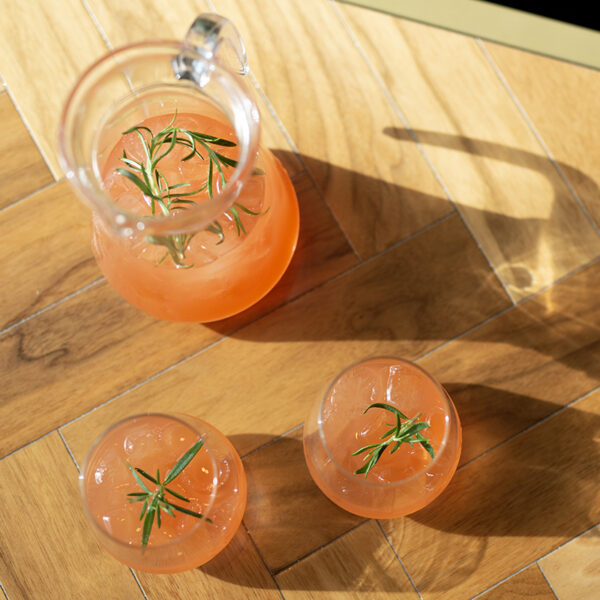 non alcoholic spritz passion fruit flavour in jug with two glasses garnished with rosemary