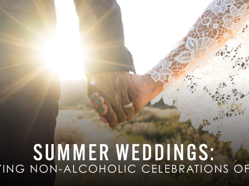 A couple holding hands with the sun shining brightly behind them, creating a warm glow. The person on the left is wearing a dark suit, and the person on the right is wearing a white lace dress. The text on the image reads 'Citizen Spritz - Summer Weddings: Enjoying Non-Alcoholic Celebrations of Love' in white letters.